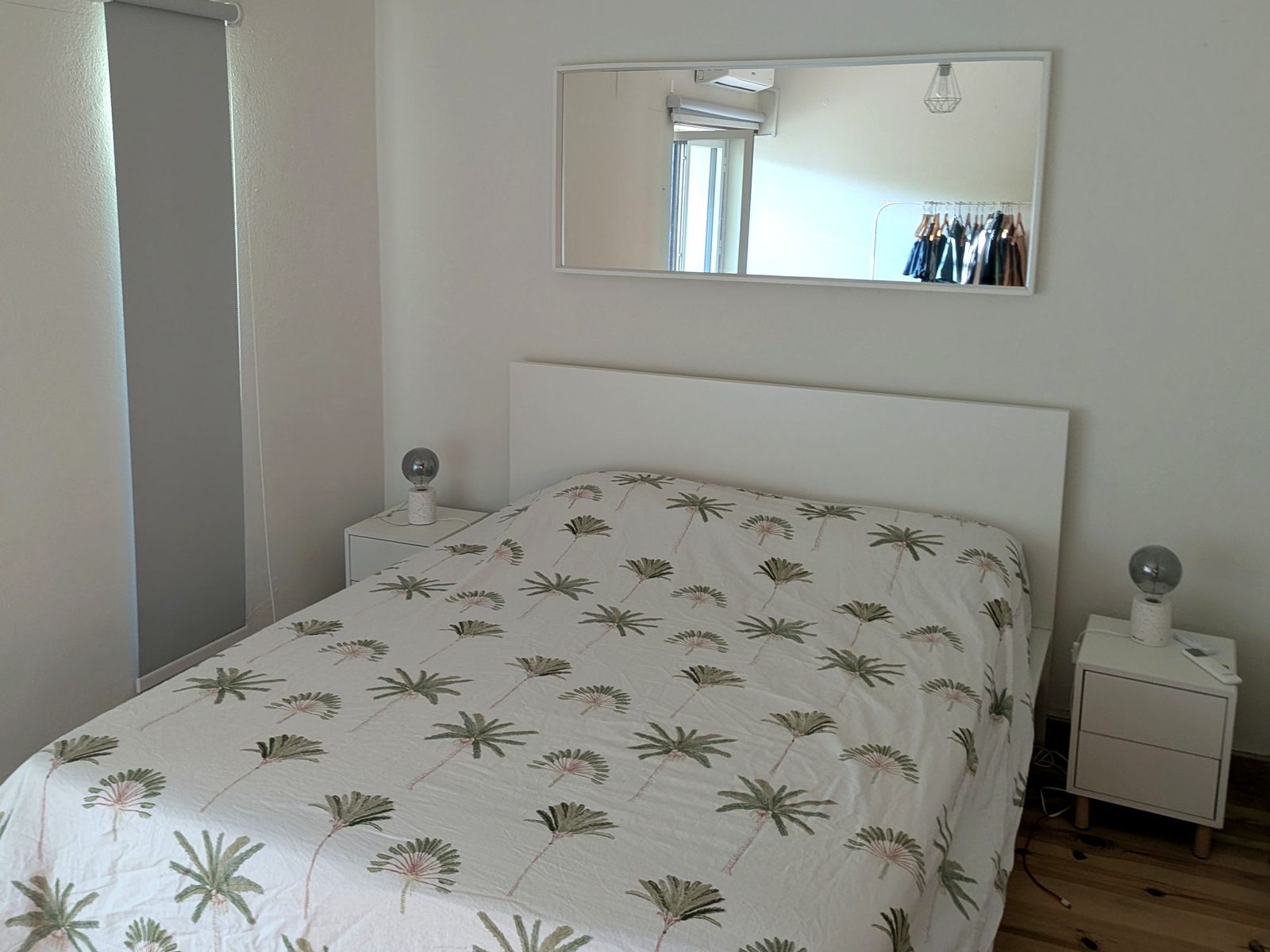 Main bedroom with a double bed and a long mirror.