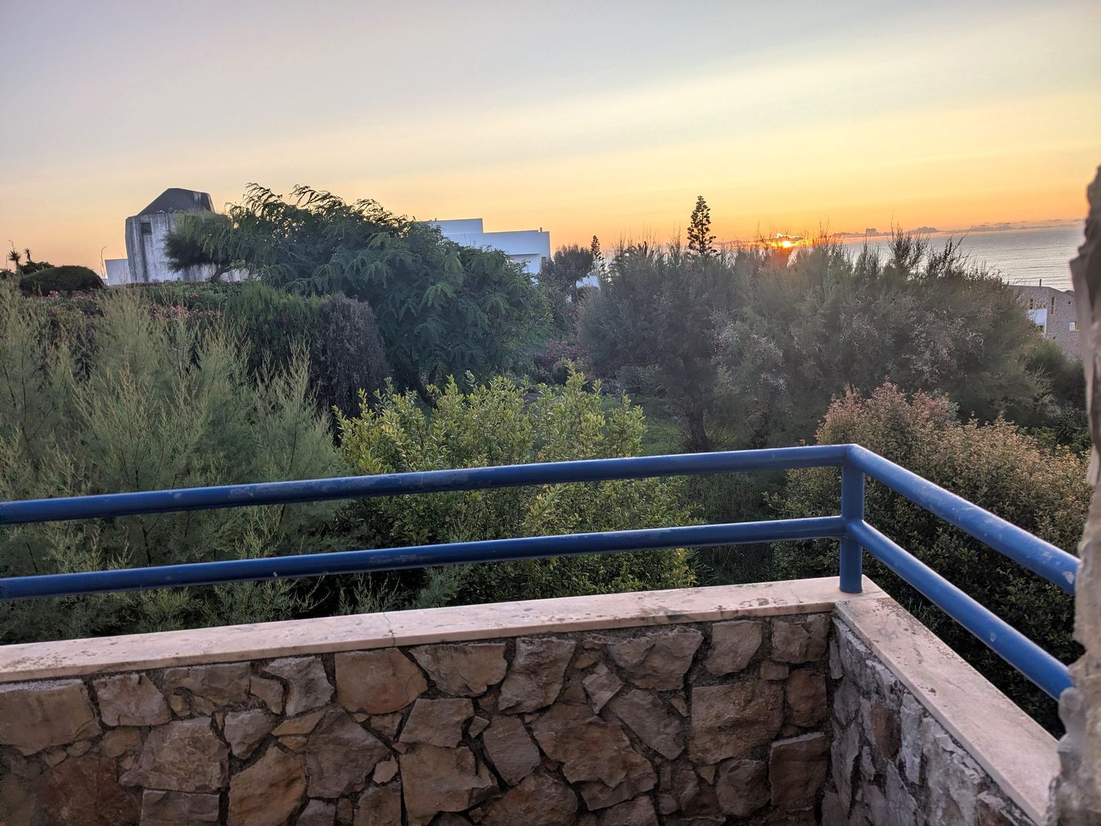 The sea from the balcony, with the blue rail in the foreground.